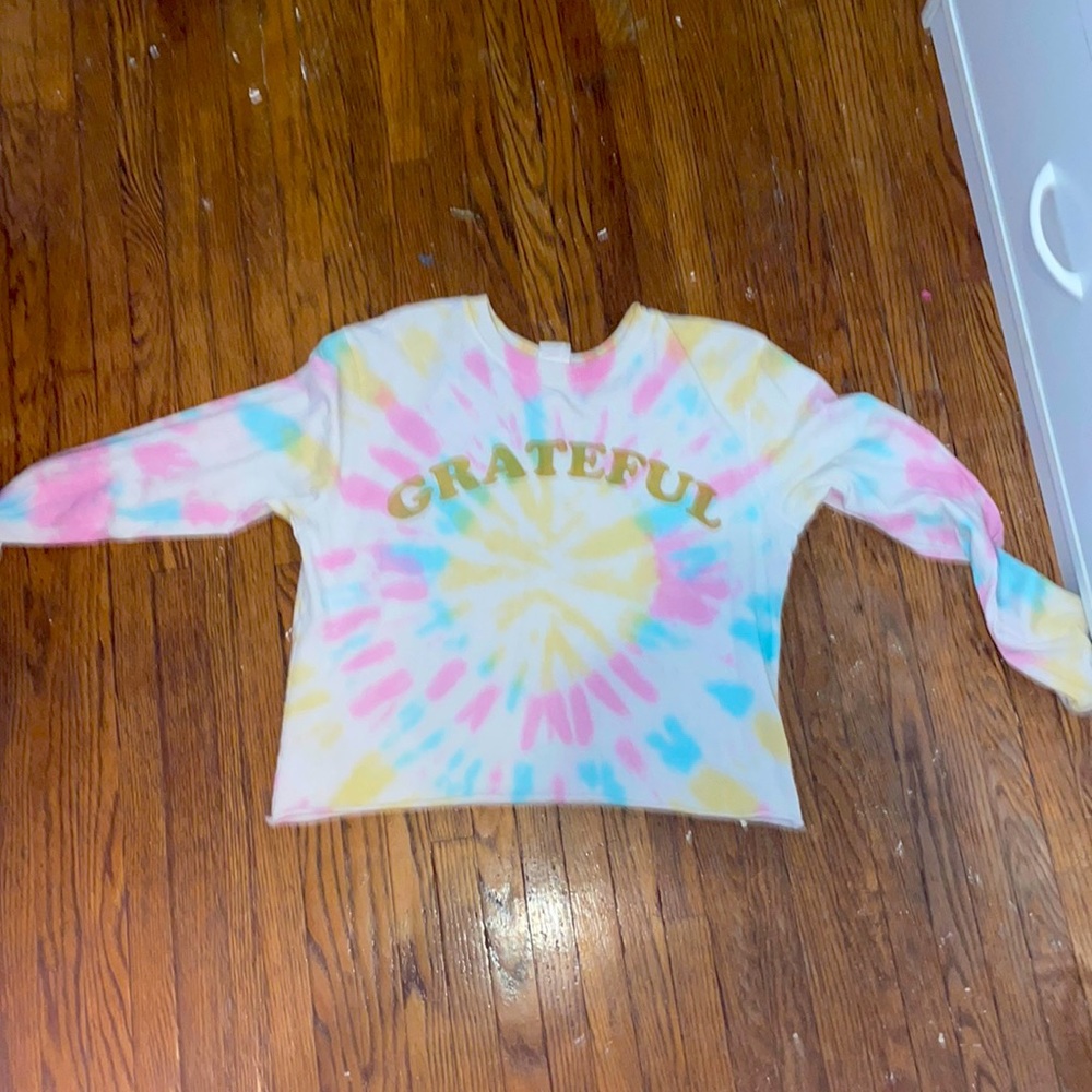 A tie die shirt and it cropped it has the word grateful on the front.